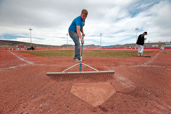 Garrett Murphy, an 11th-grade-student at Grants High School, combs over home plate in preperation for a varsity baseball game in Grants on Tuesday.  © 2011 Gallup Independent / Adron Gardner 